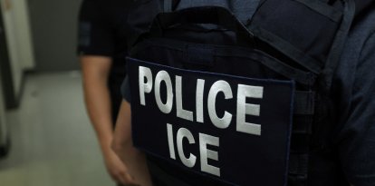 An agent of Immigration and Customs Enforcement (ICE) waits in a hallway outside of a courtroom at New York Federal Plaza Immigration Court inside the Jacob K. Javitz Federal Building in New York on July 17, 2025. US President Donald Trump has made deporting undocumented immigrants a key priority for his second term, after successfully campaigning against an alleged "invasion" by criminals. (Photo by CHARLY TRIBALLEAU / AFP)